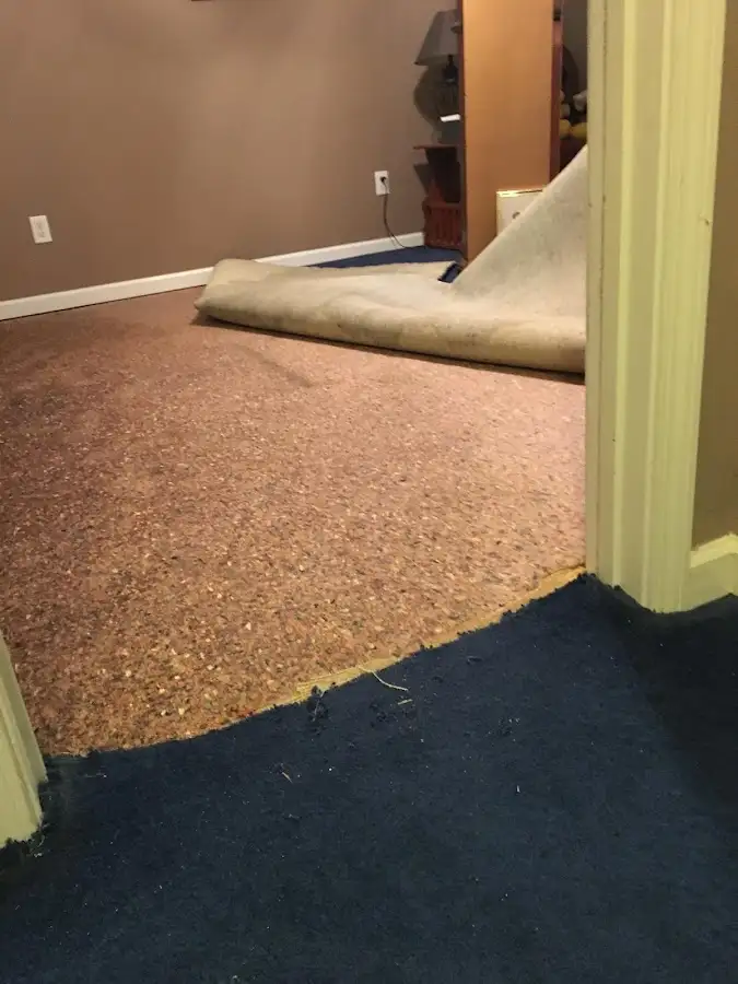Carpet pad removal revealing water damage during Drying & Dehumidification in Emporia